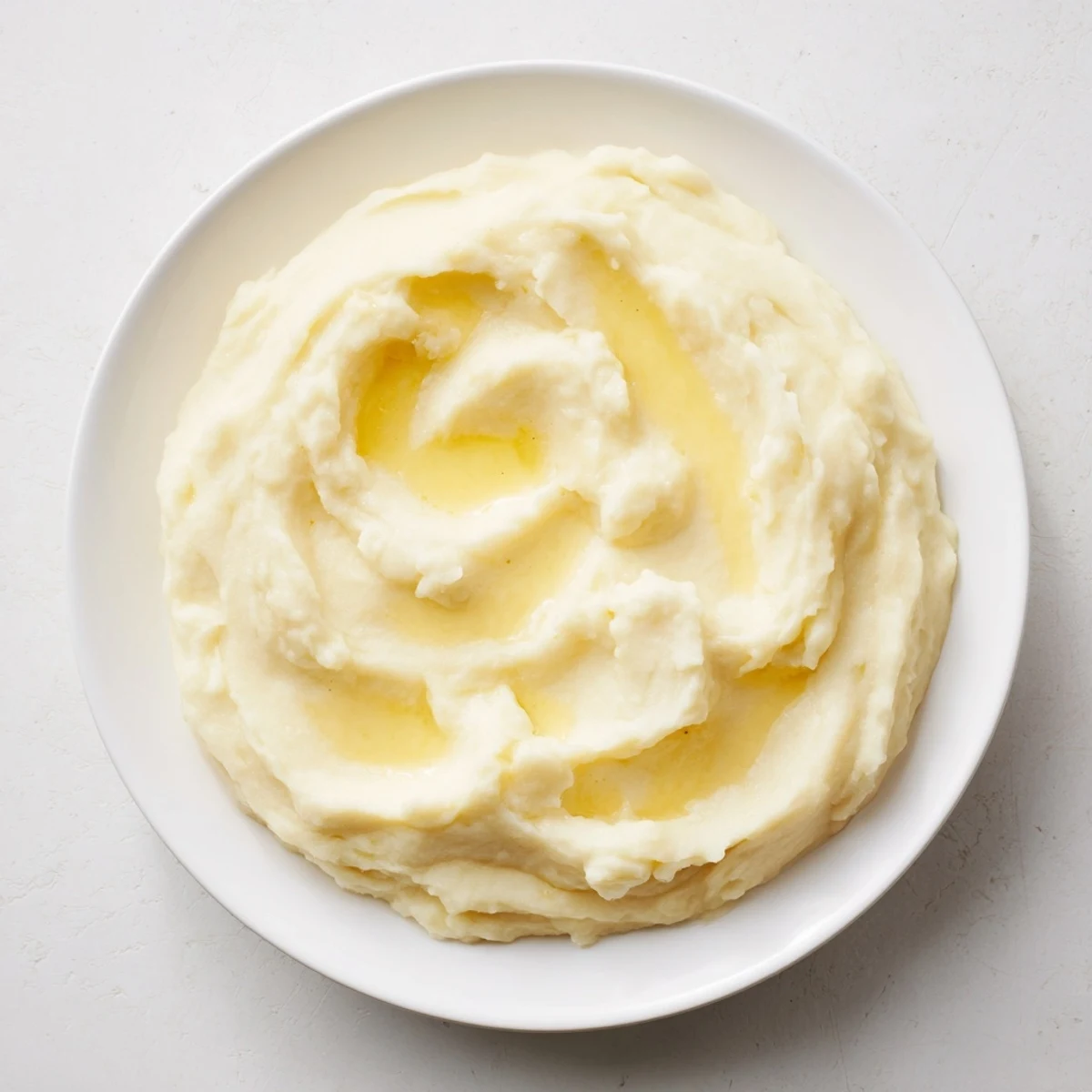 Buttery, creamy mash, a glistening pile of smooth potatoes in a serving bowl.