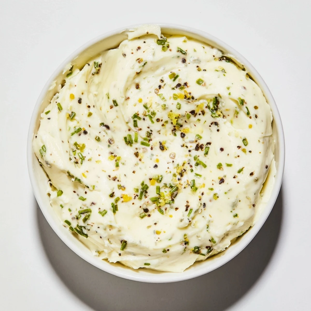 Serving a bowl of the creamy cheese spread: a savory appetizer with fresh herbs on top for dipping.