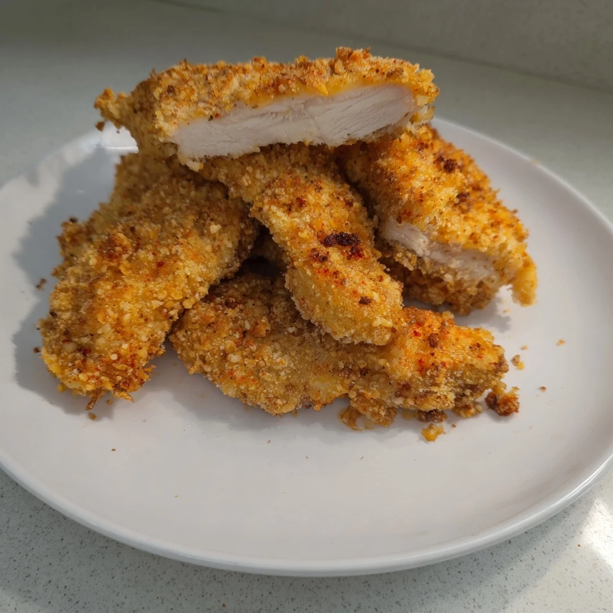 Hot and crispy chicken tenders, a classic American meal, served with a side of creamy ranch.