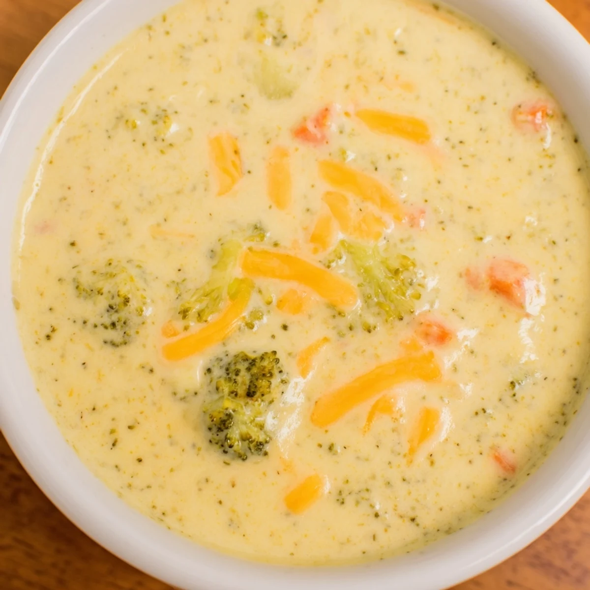 Creamy Broccoli and Cheese Soup in a warm bowl, garnished with extra cheese, ready to eat.
