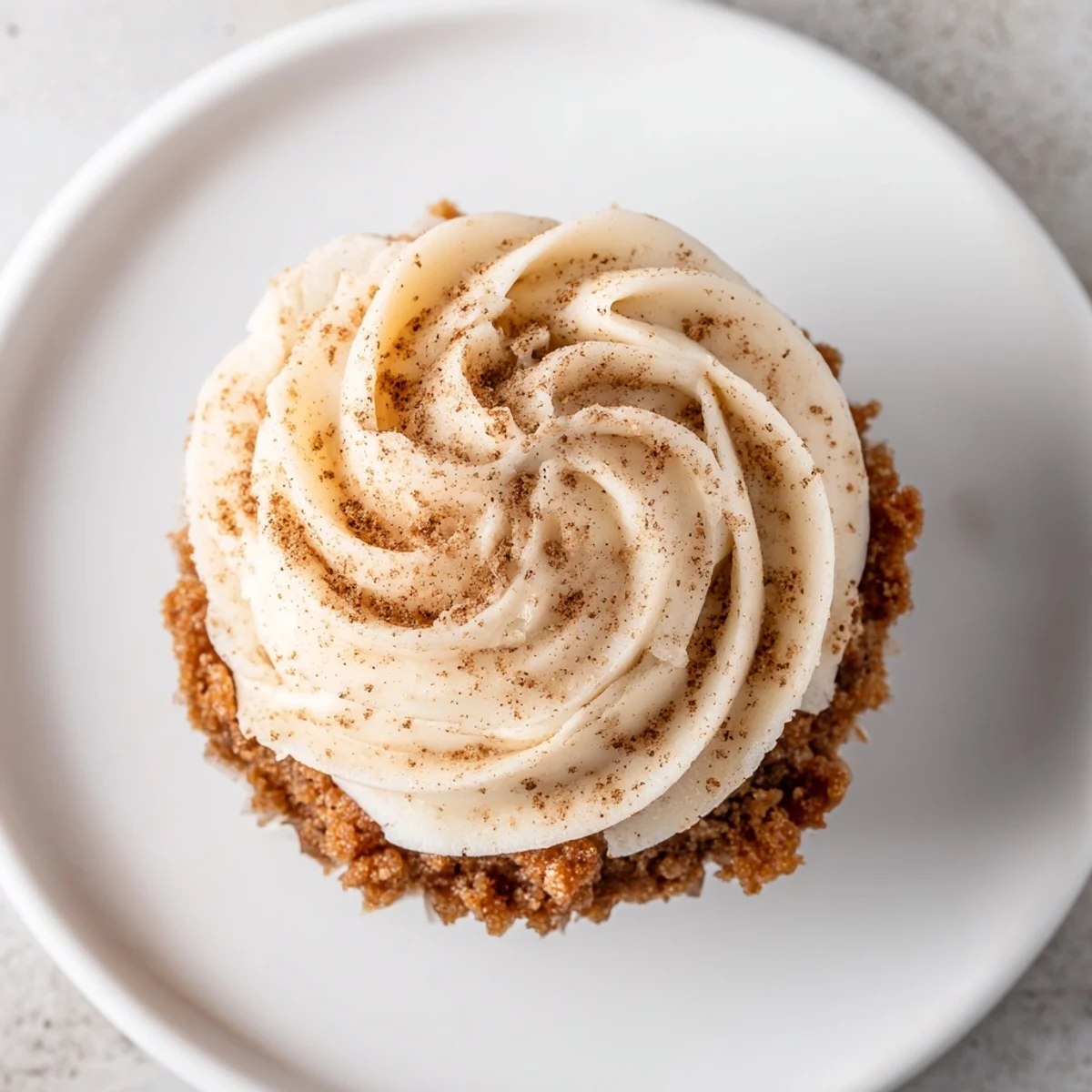 Golden gingerbread cupcakes, perfectly risen with fluffy frosting, ready for a cozy afternoon treat.