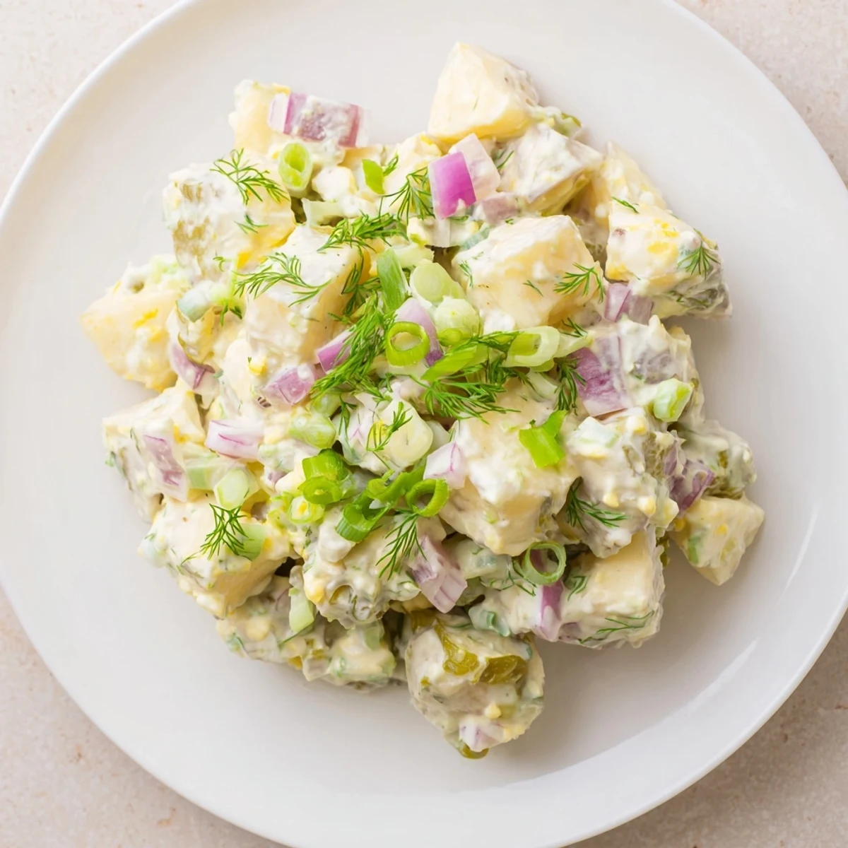 A bowl of fresh, colorful creamy potato salad, perfect for a summer picnic or barbecue.