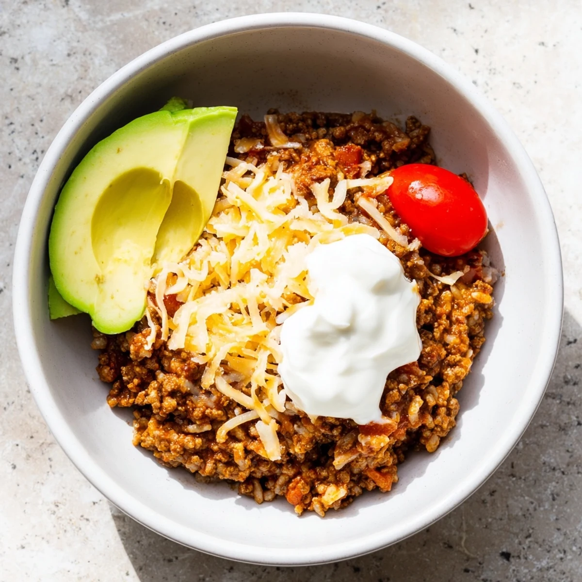 Plated Beef Burrito Bowls with cilantro, lime wedges, and corn, ready to serve with a fork on a rustic table.