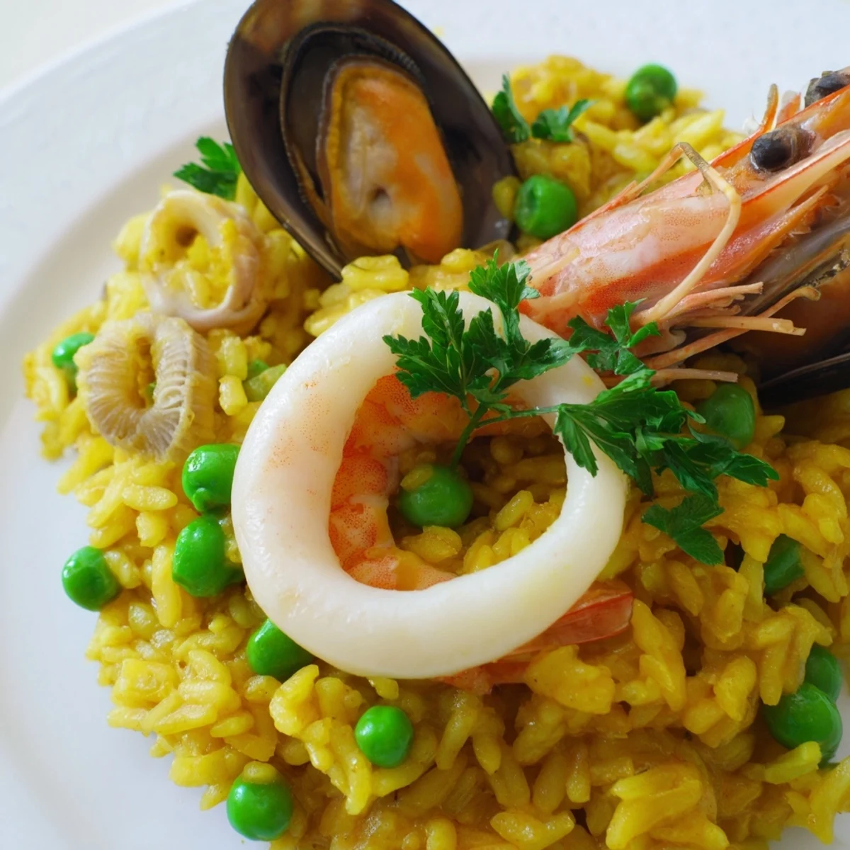 Steaming seafood paella with saffron rice, colorful peppers, peas, and lemon wedges for a romantic dinner.  