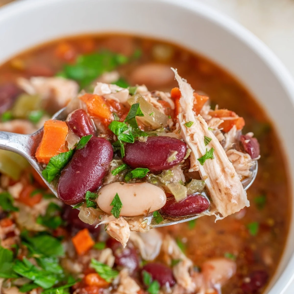 Creole Bean Soup with Turkey simmering in a pot, with diced vegetables and kidney beans visible in a savory, spiced broth.