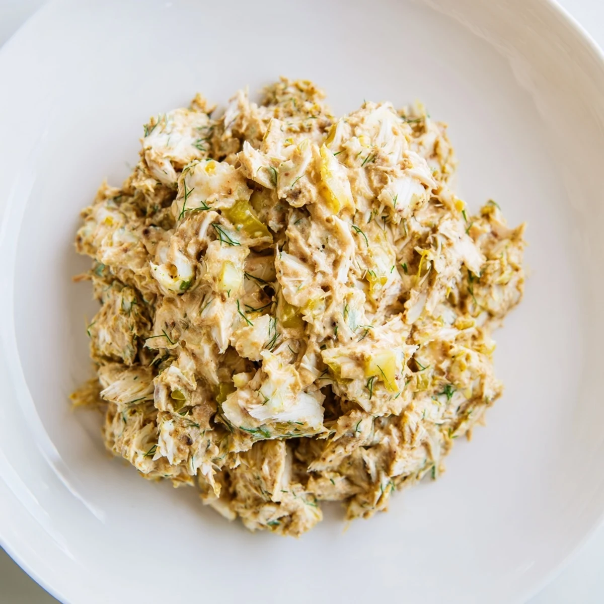 Spicy Cajun Remoulade Sauce with Crab in a white bowl beside crisp crackers and lemon wedges, ready for a snack.