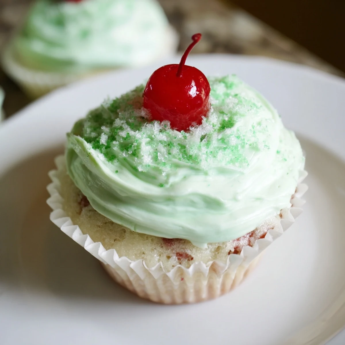 Green Shamrock Shake Cupcakes topped with fluffy mint frosting and green sprinkles, perfect for St. Patrick's Day celebrations.