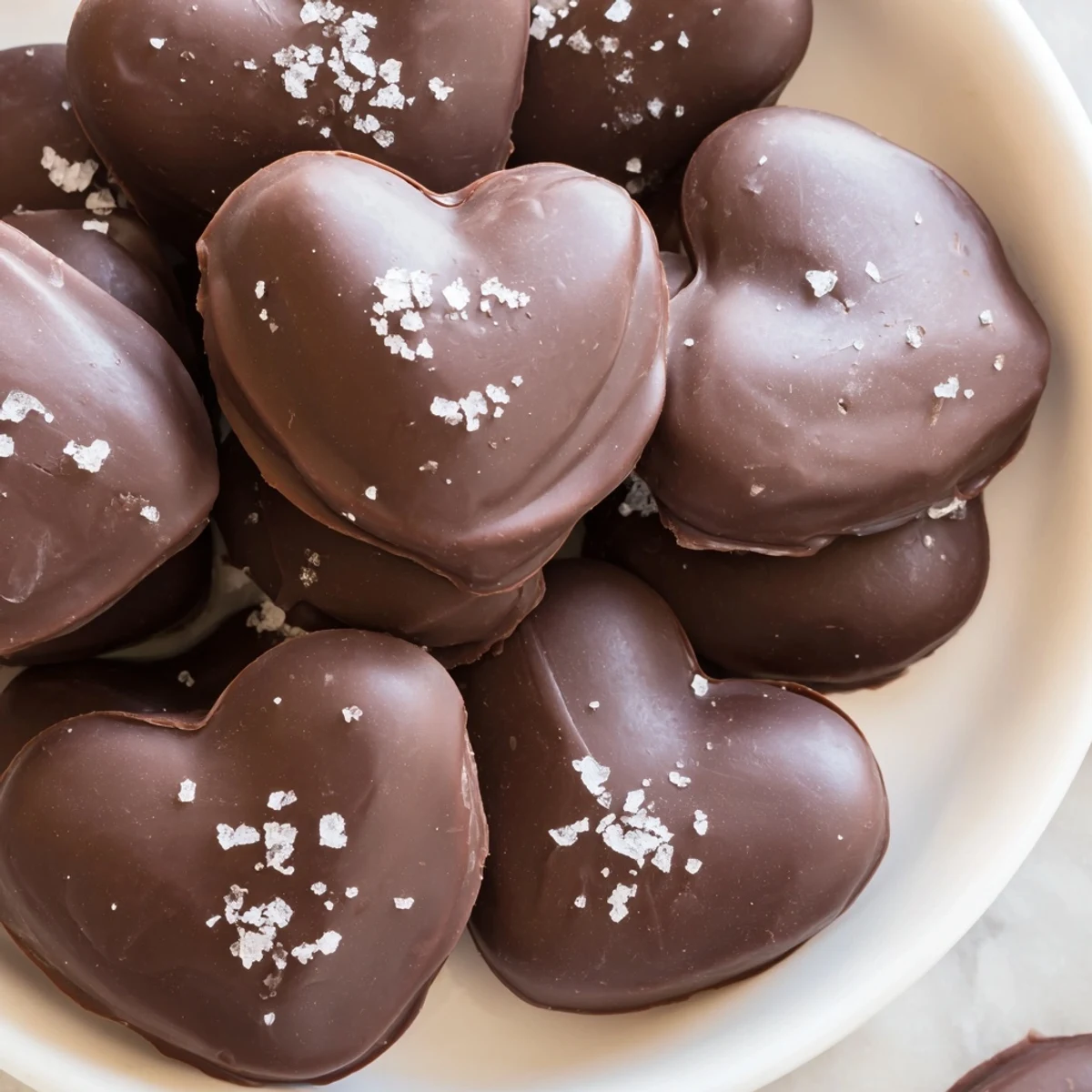 Close-up view of a chocolate peanut butter heart, revealing a creamy peanut butter center and a smooth, dark chocolate shell.