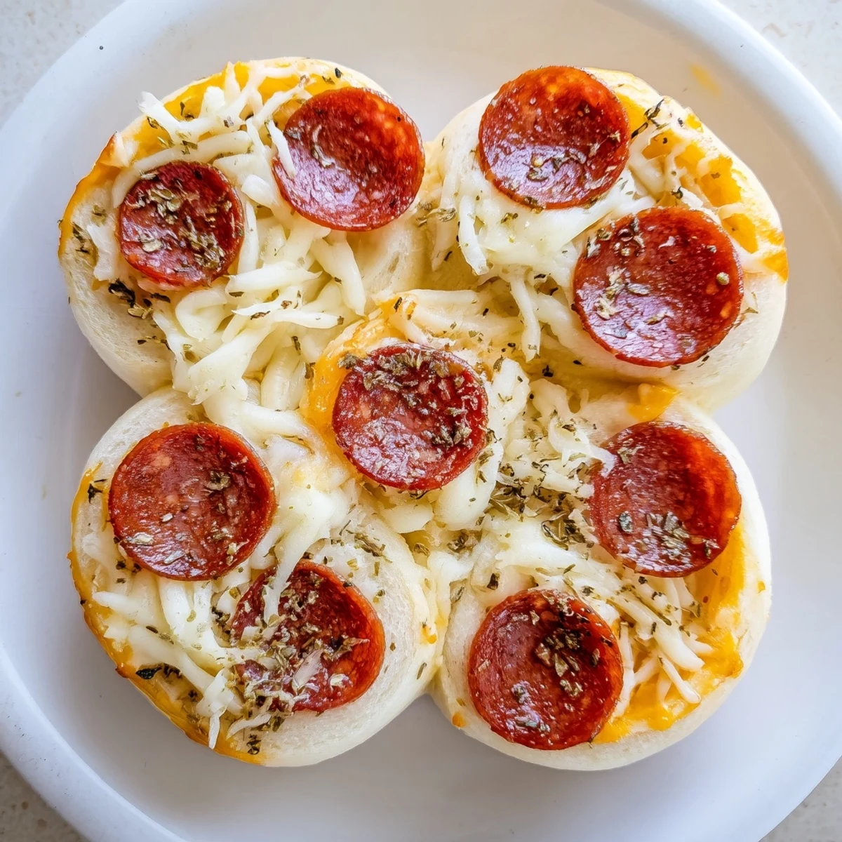 Freshly baked Pizza Rolls with Beef Pepperoni and Cheese display golden crusts, melted cheese, and pepperoni peeking from the edges.  