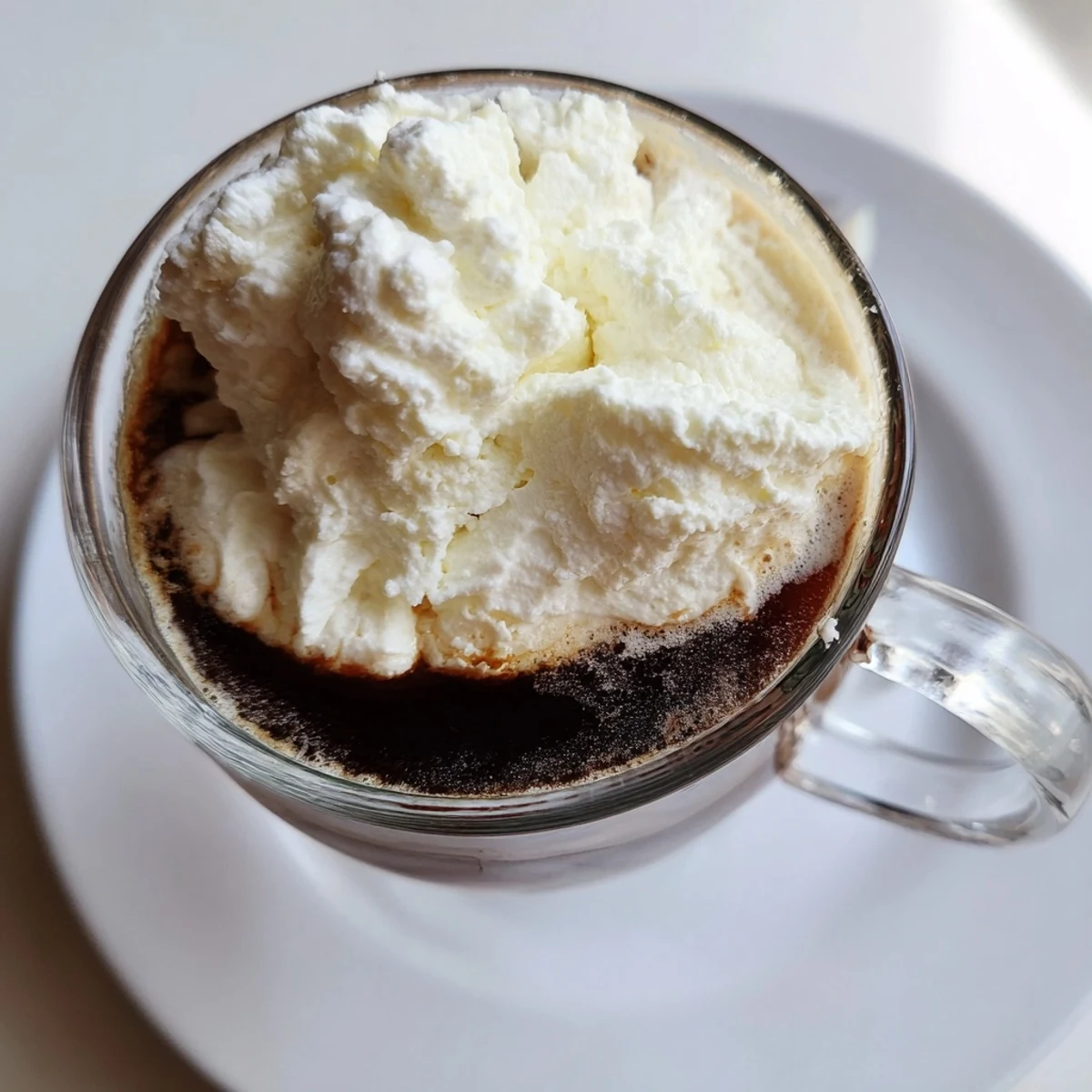A warm mug of Irish Coffee Mocktail with Whipped Cream topped with creamy foam.