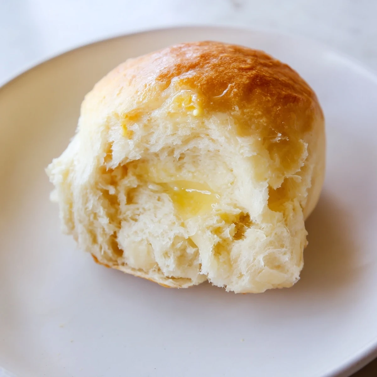 Golden-brown, fluffy Best Vegan Dinner Rolls fresh from the oven, brushed with melted vegan butter and ready to serve warm.
