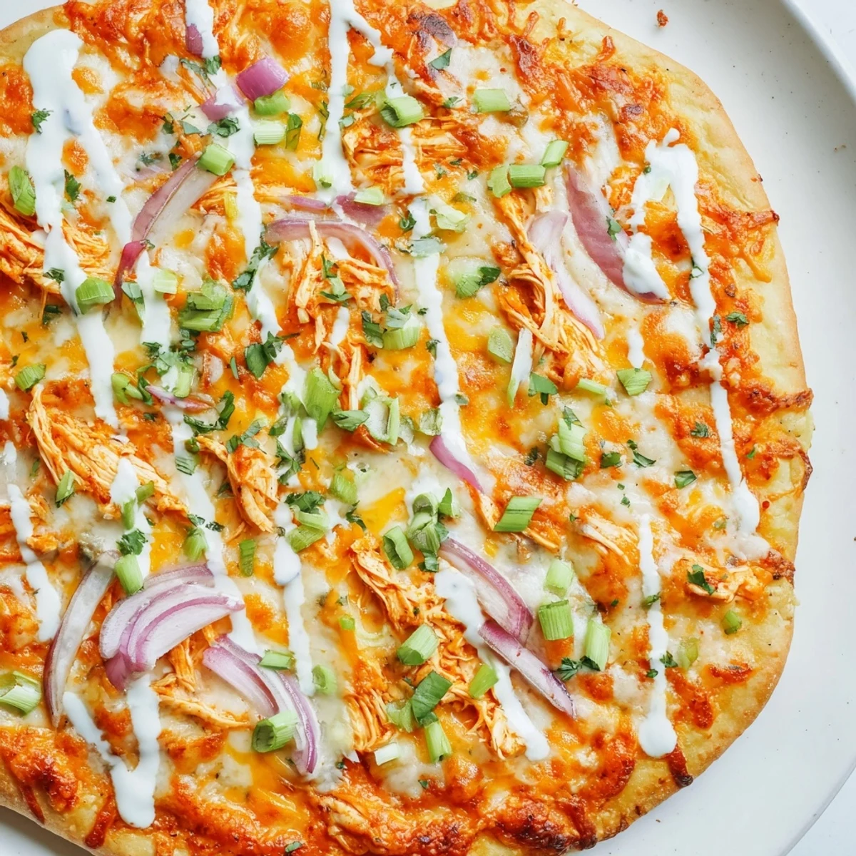 Bold Buffalo Chicken Pizza served hot with red onion slices and fresh cilantro garnish.