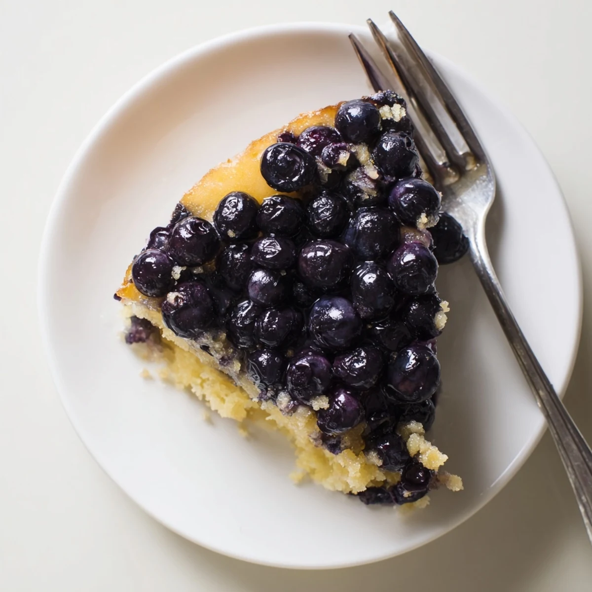 Fresh blueberry upside down cake flipped from pan showing glossy berry topping