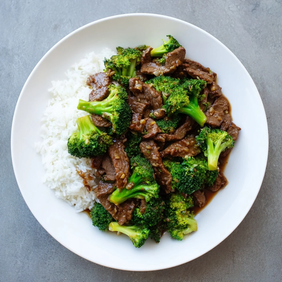 Tender beef and broccoli stir-fry glistening with savory garlic sauce over steaming white rice