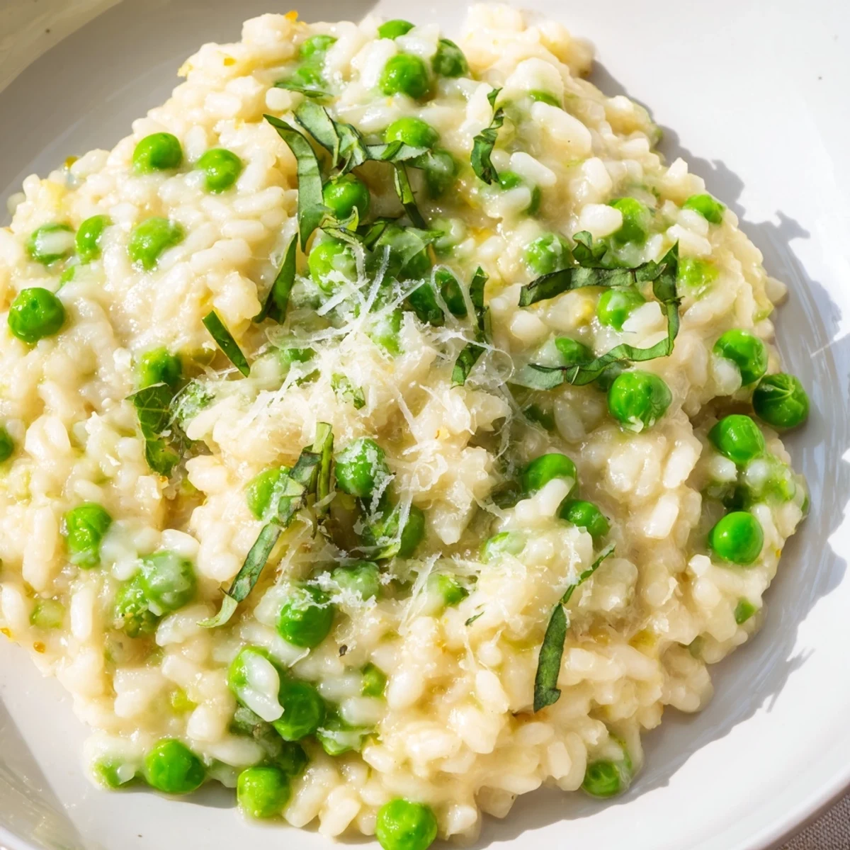 Vibrant green pea risotto served steaming hot with nutty Parmesan and fresh herbs
