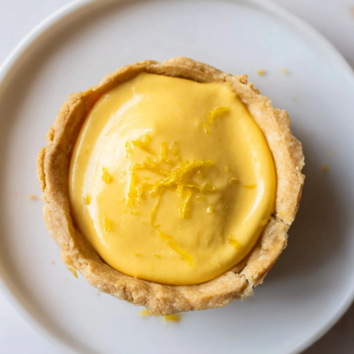Golden mini vegan lemon tarts with creamy coconut filling in crisp pastry shells