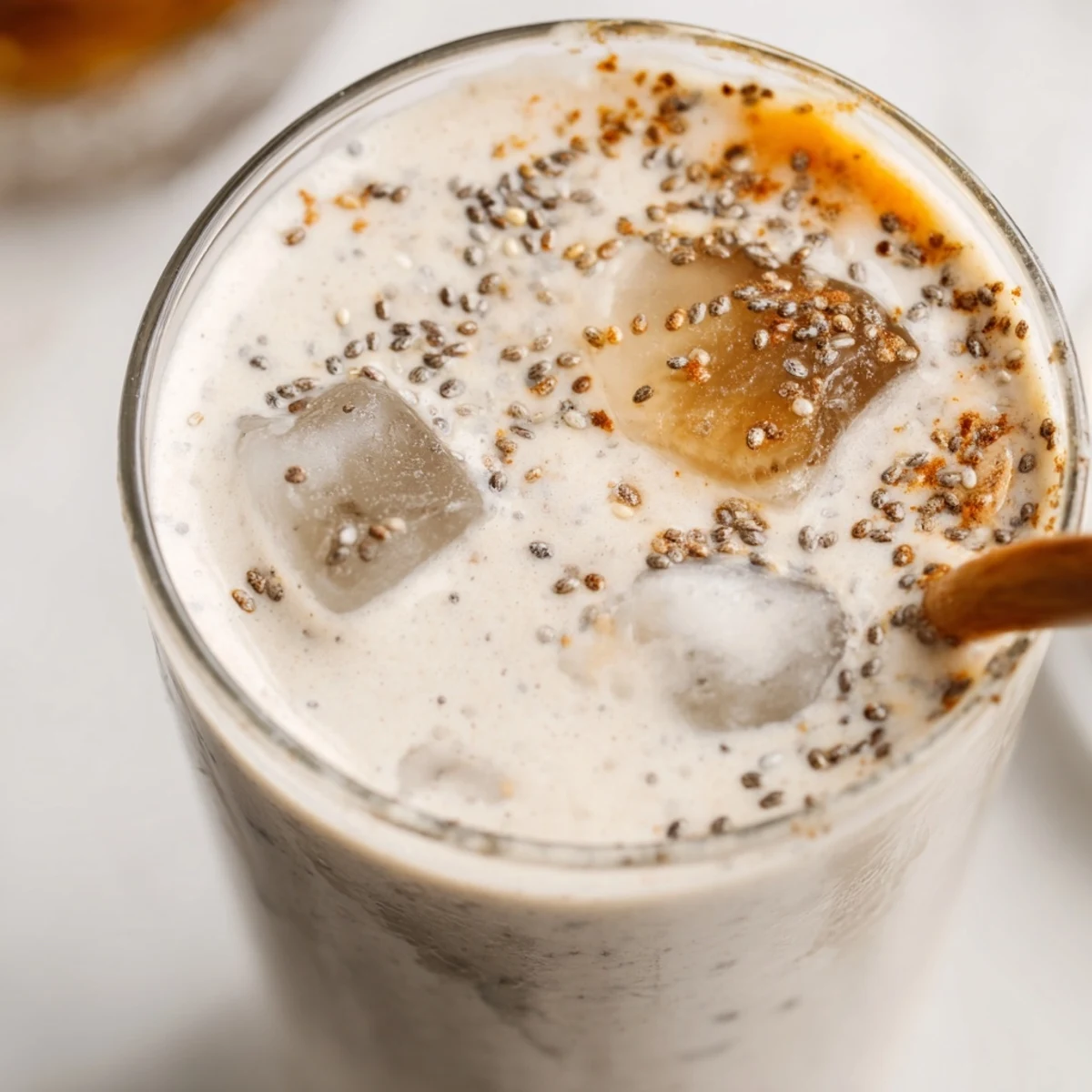 Thick and frothy Greek yogurt banana smoothie poured into a tall clear glass