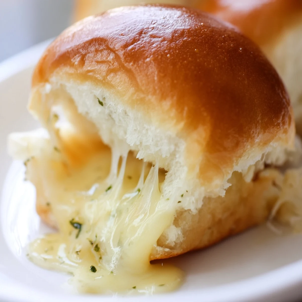 Batch of twelve mini grilled cheese sandwiches on Hawaiian rolls with garlic butter brushed tops