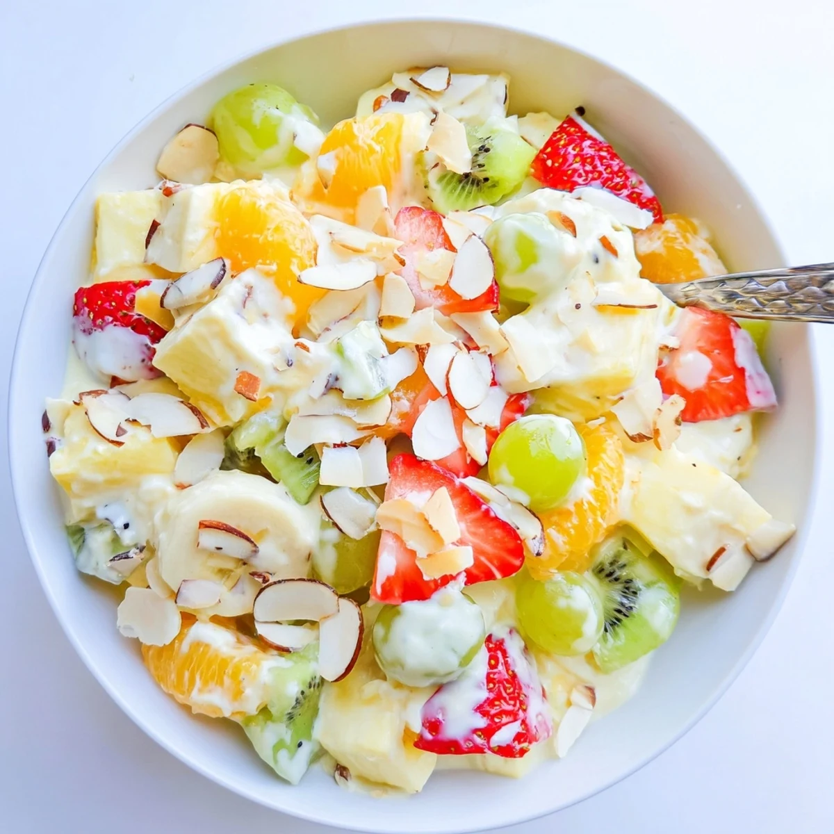 Luscious creamy fruit salad displaying kiwi, mandarin oranges, and banana slices in silky honey dressing