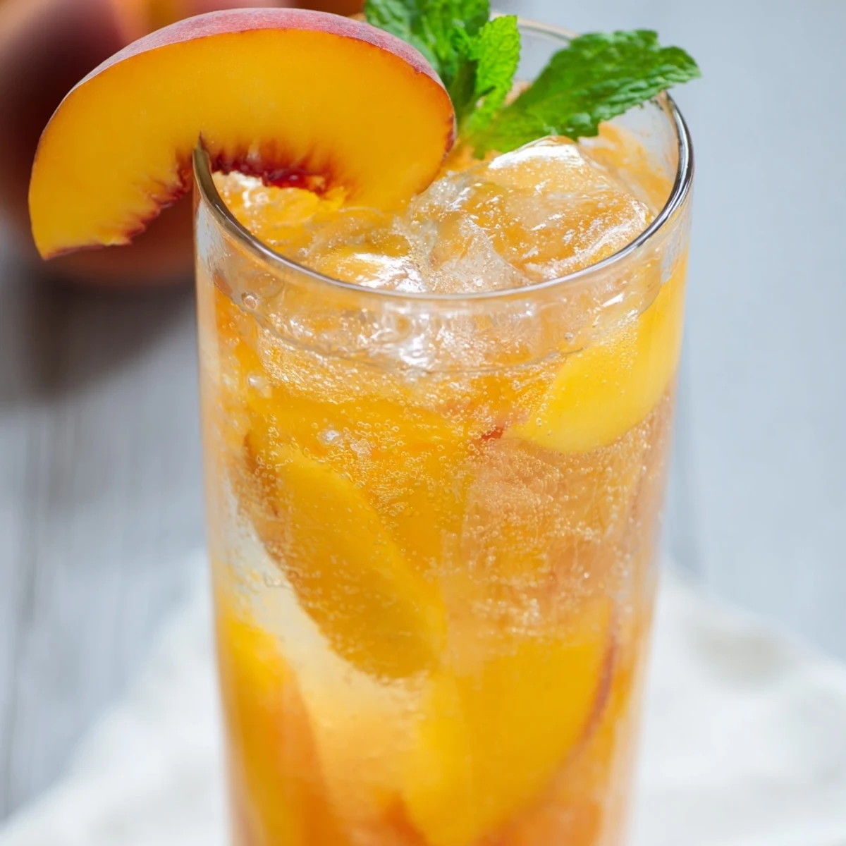 Refreshing ginger peach sparkler poured over ice with bubbly sparkling water
