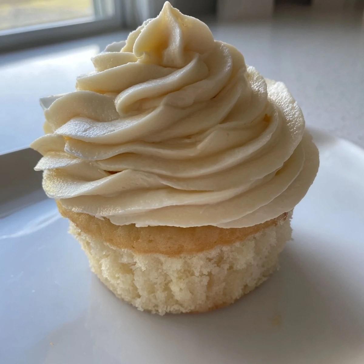 Light and fluffy homemade vanilla cupcakes with swirled frosting and colorful sprinkle decorations