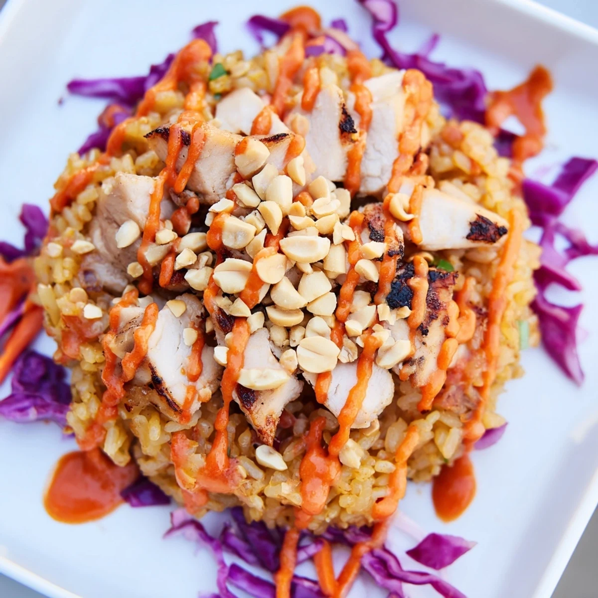 Golden crispy rice crowns this vibrant Bang Bang Chicken salad drizzled with creamy spicy sauce