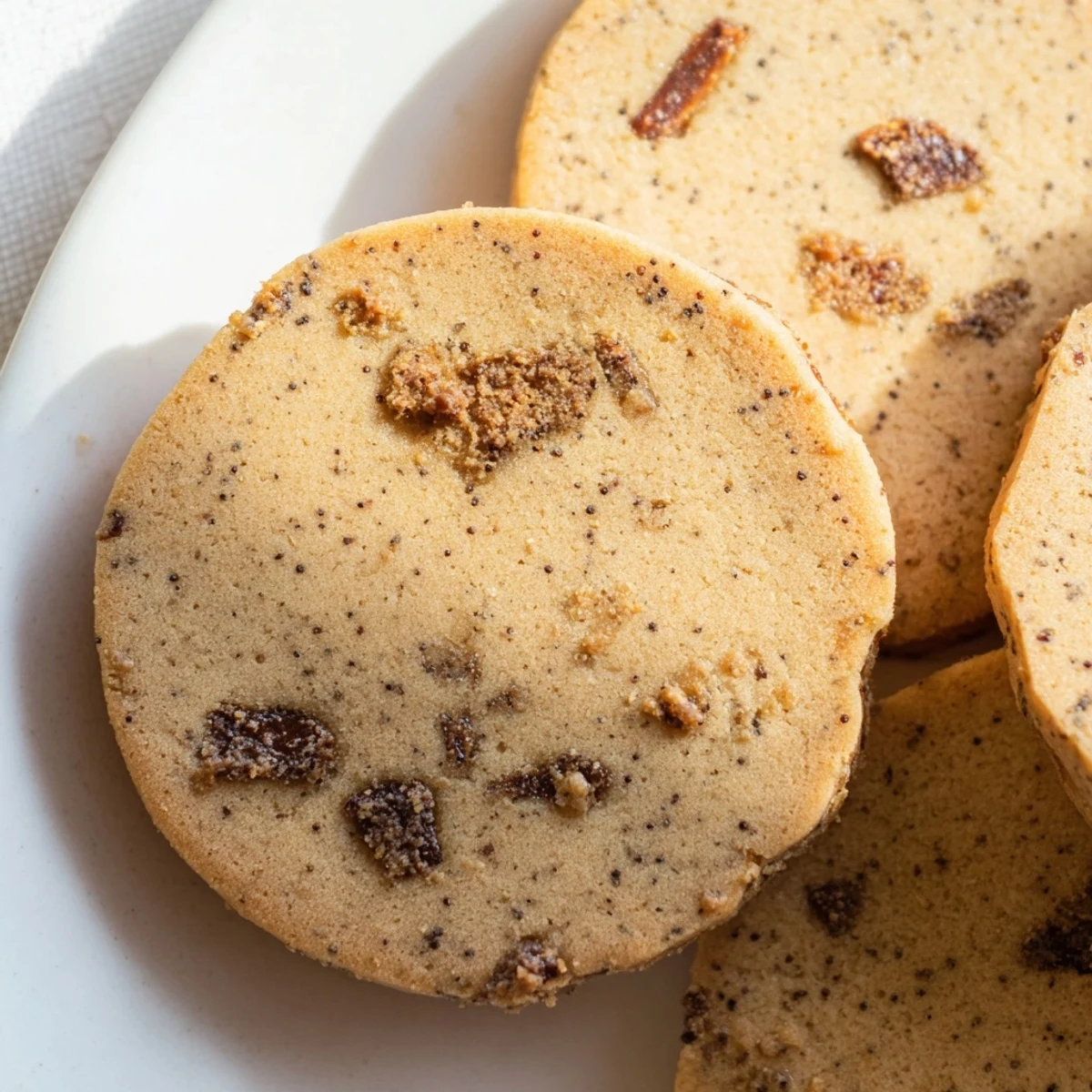 Rich espresso shortbread cookies with caramelized toffee pieces arranged beside a steaming coffee mug