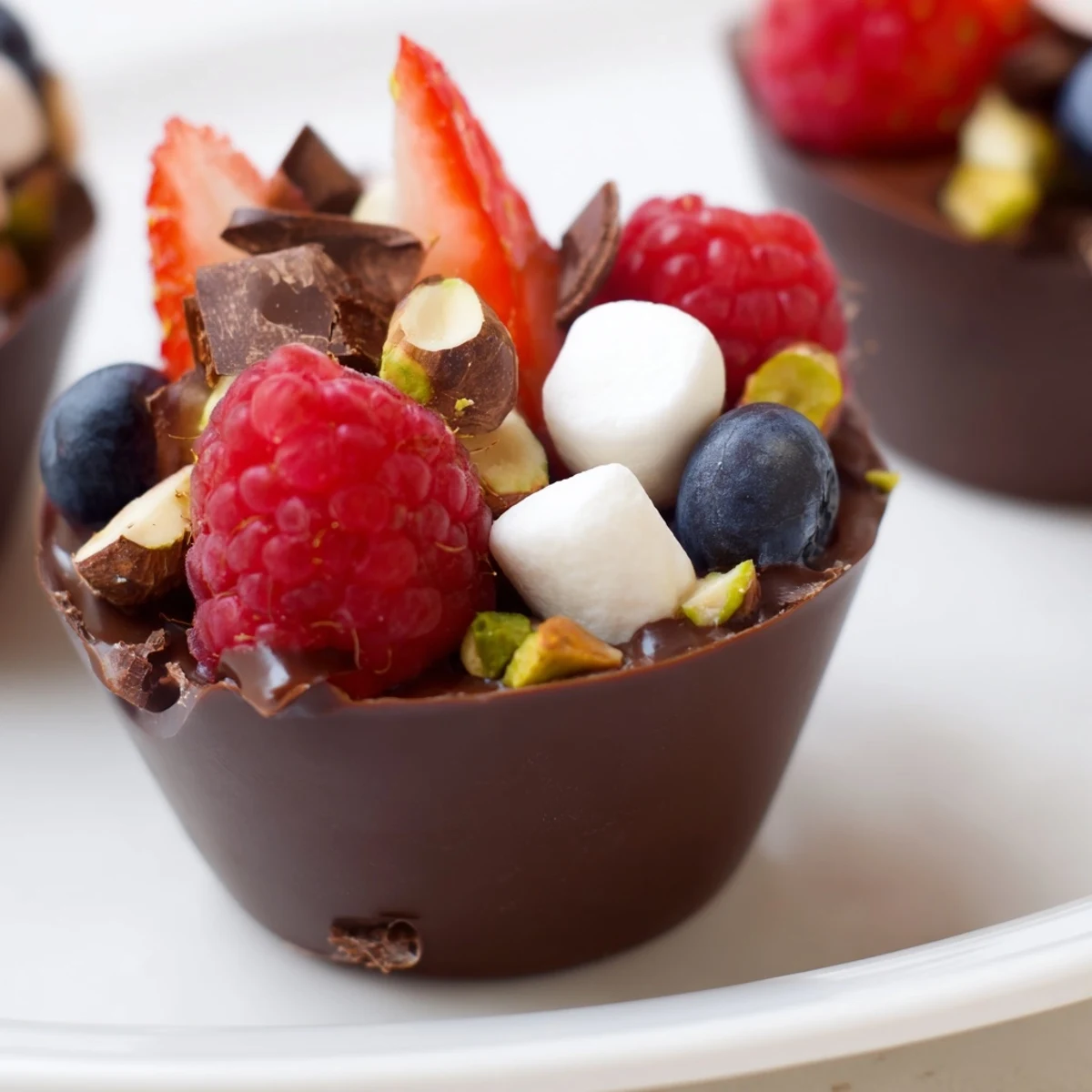 Chocolate grazing cups filled with silky mousse and topped with fresh berries and nuts