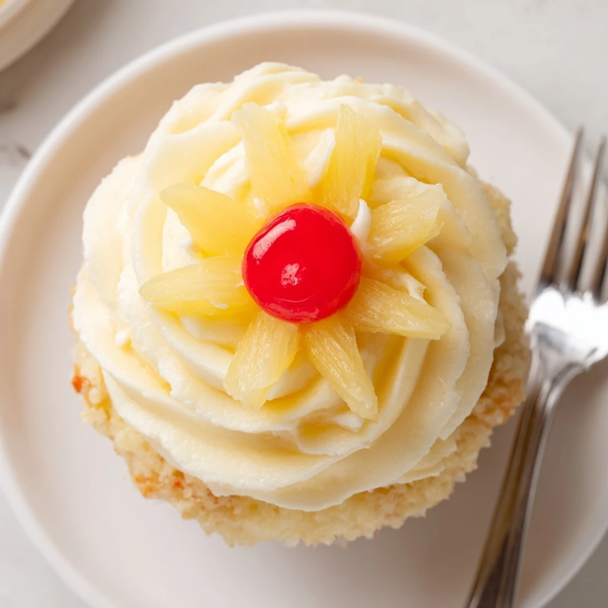 A plate of Dole Whip Cupcakes Recipe served with dried pineapple and cherries