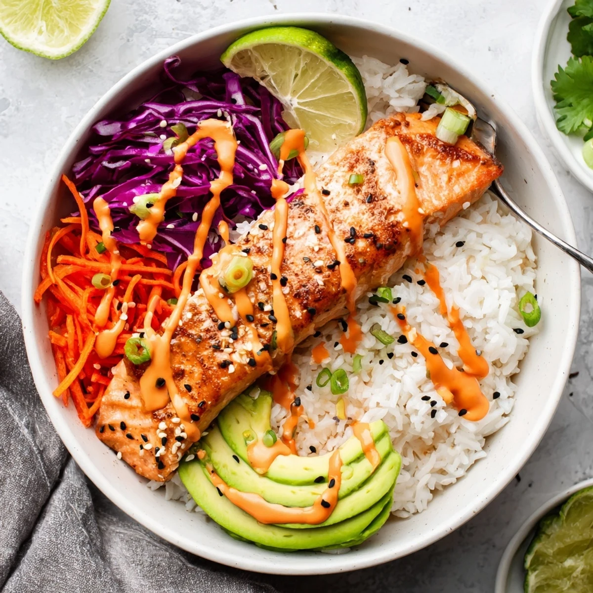 Sheet pan roasted Bang Bang Salmon Bowls served over jasmine rice, crunchy cabbage