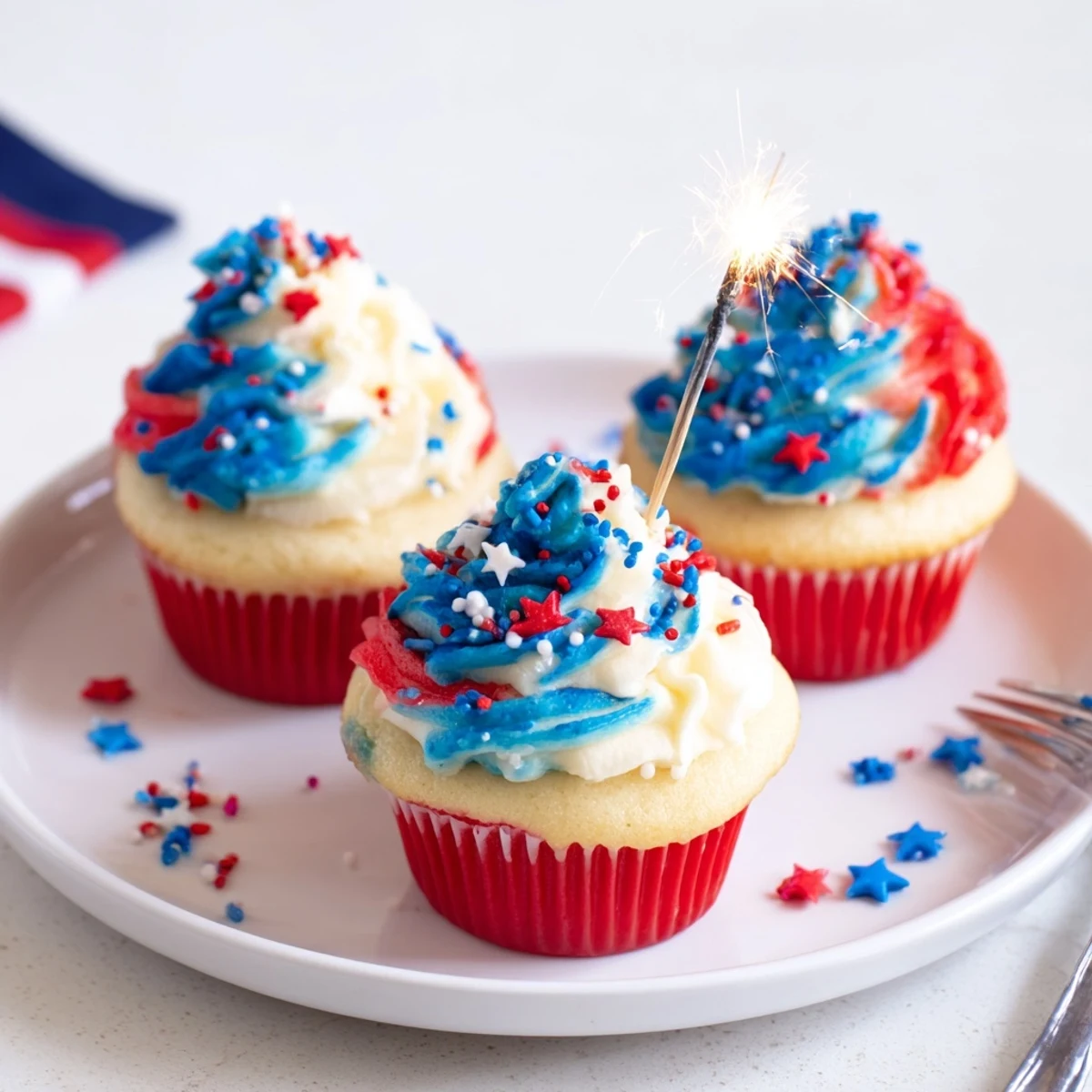 Patriotic Firework Cupcakes with tall red, white, and blue buttercream swirls
