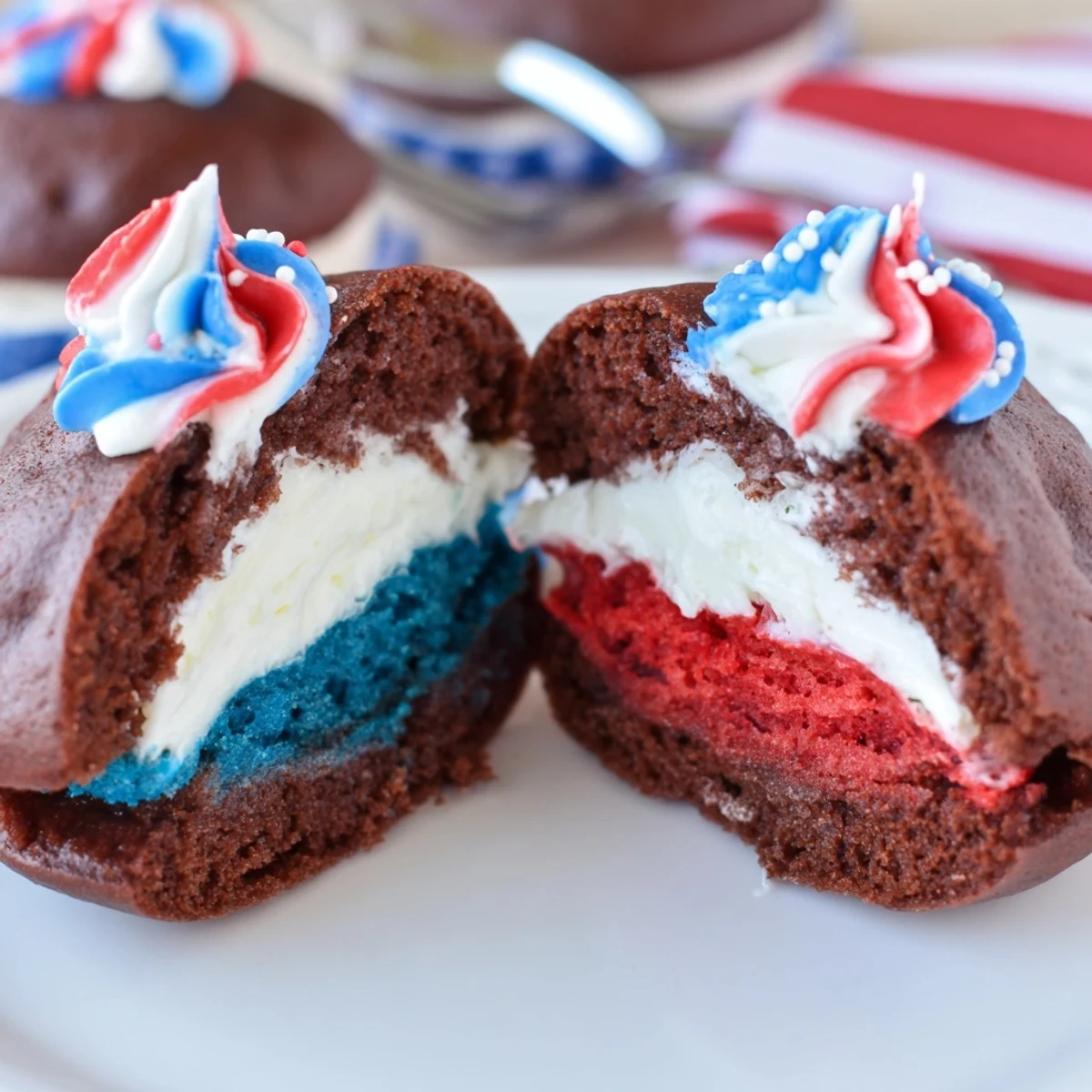 A stack of Patriotic Whoopie Pies rests on a picnic plate, creamy frosting inside