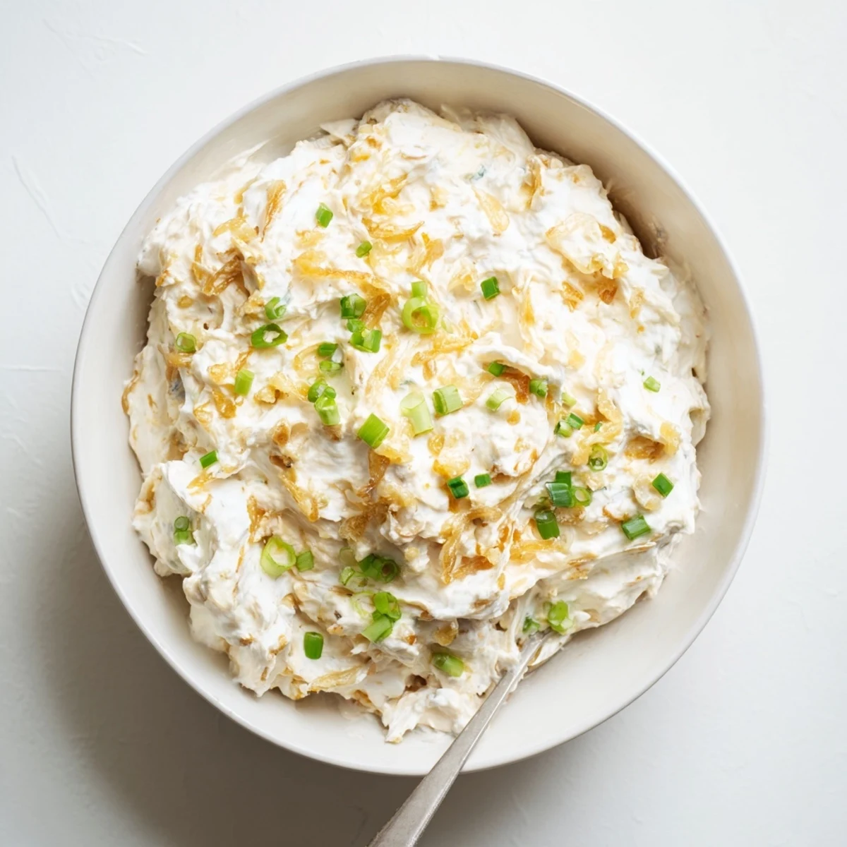 Homemade French onion dip with golden brown caramelized onions mixed into smooth sour cream base