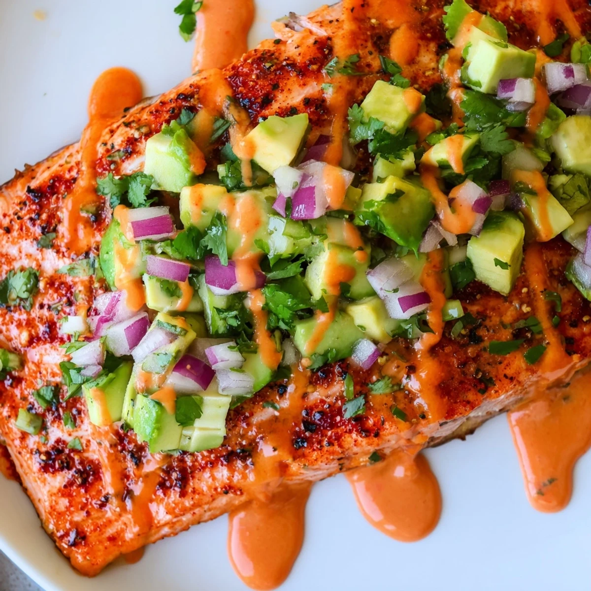 Crispy-edged bang bang salmon drizzled with creamy sauce and fresh green salsa