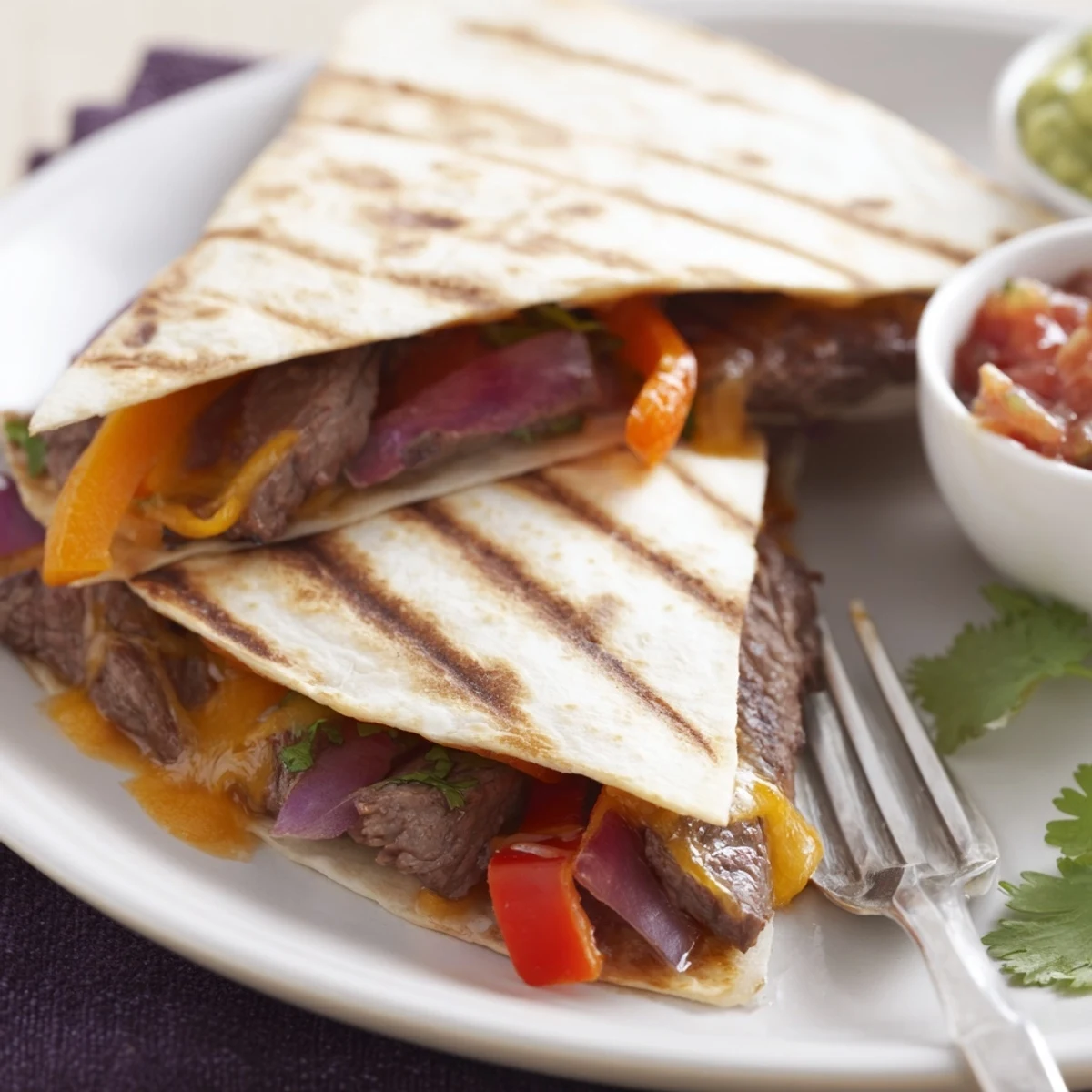 Golden steak quesadillas with melted cheese, sautéed peppers, and fresh cilantro on a wooden board