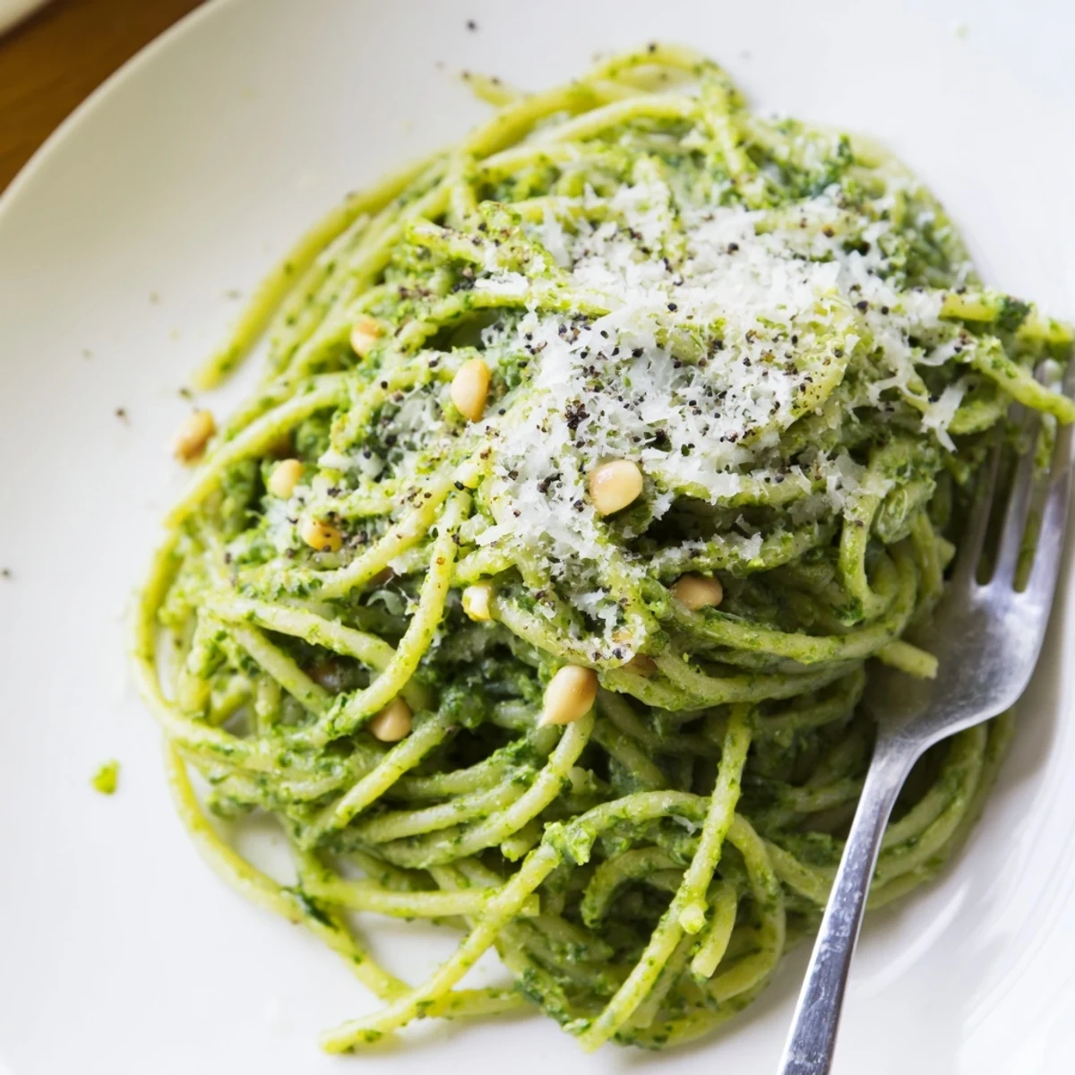 Creamy wild garlic pesto pasta coated in bright green herb sauce with pine nuts