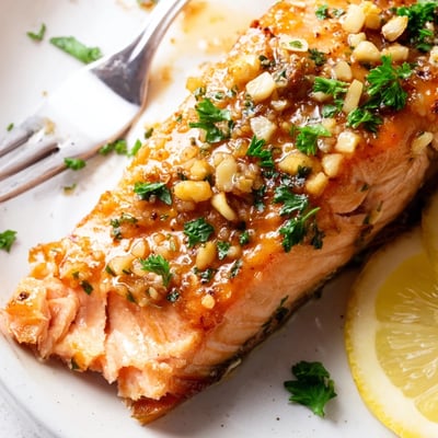 Perfectly flaky Baked Salmon with Honey Garlic Glaze paired with roasted asparagus and lemon wedges.