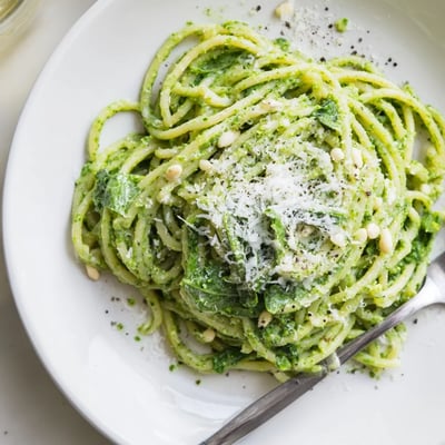 Wild garlic pesto pasta twirled on a fork with freshly grated Parmesan on top
